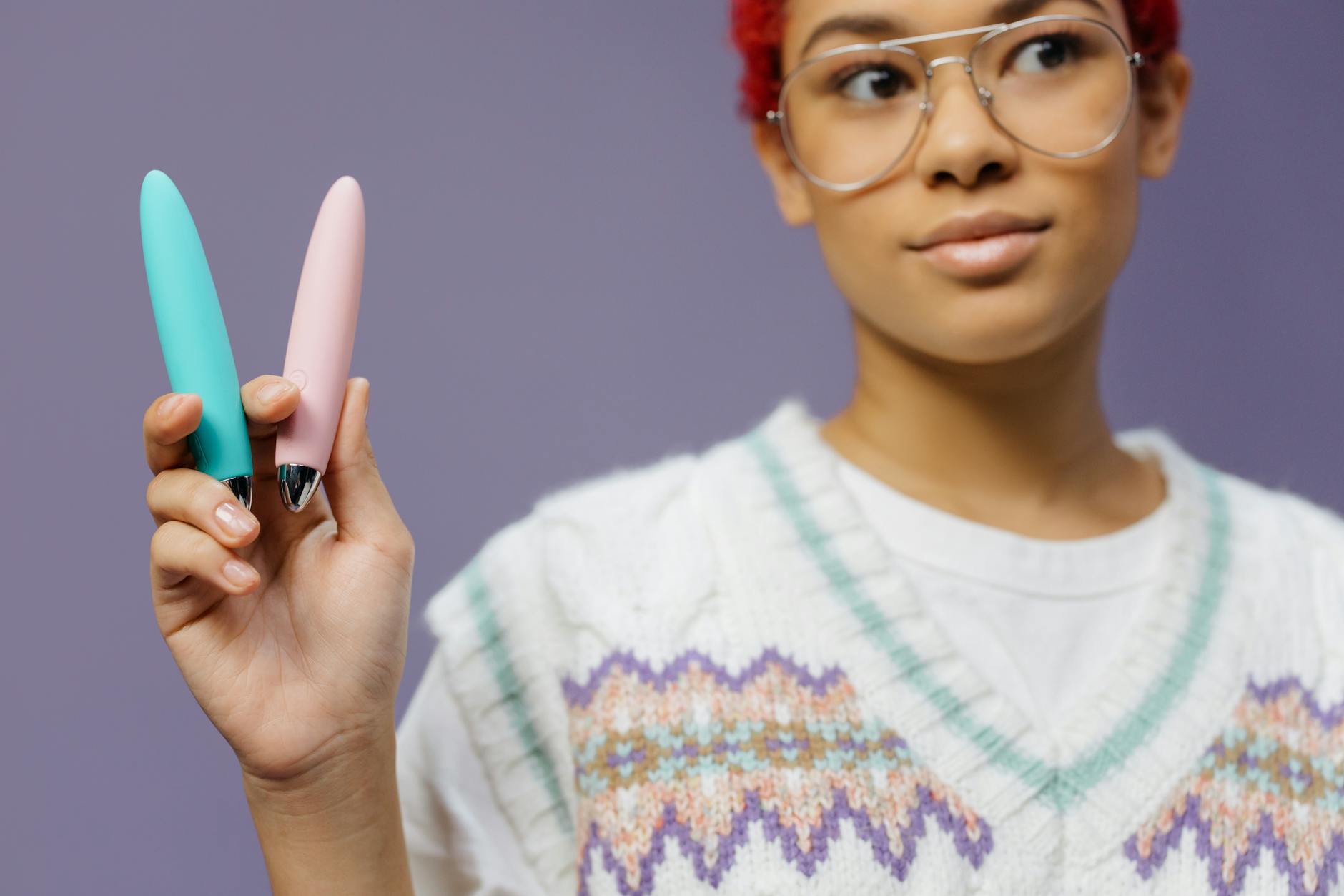 A woman holding colorful vibrators, representing modern pleasure tools for midlife sexuality.