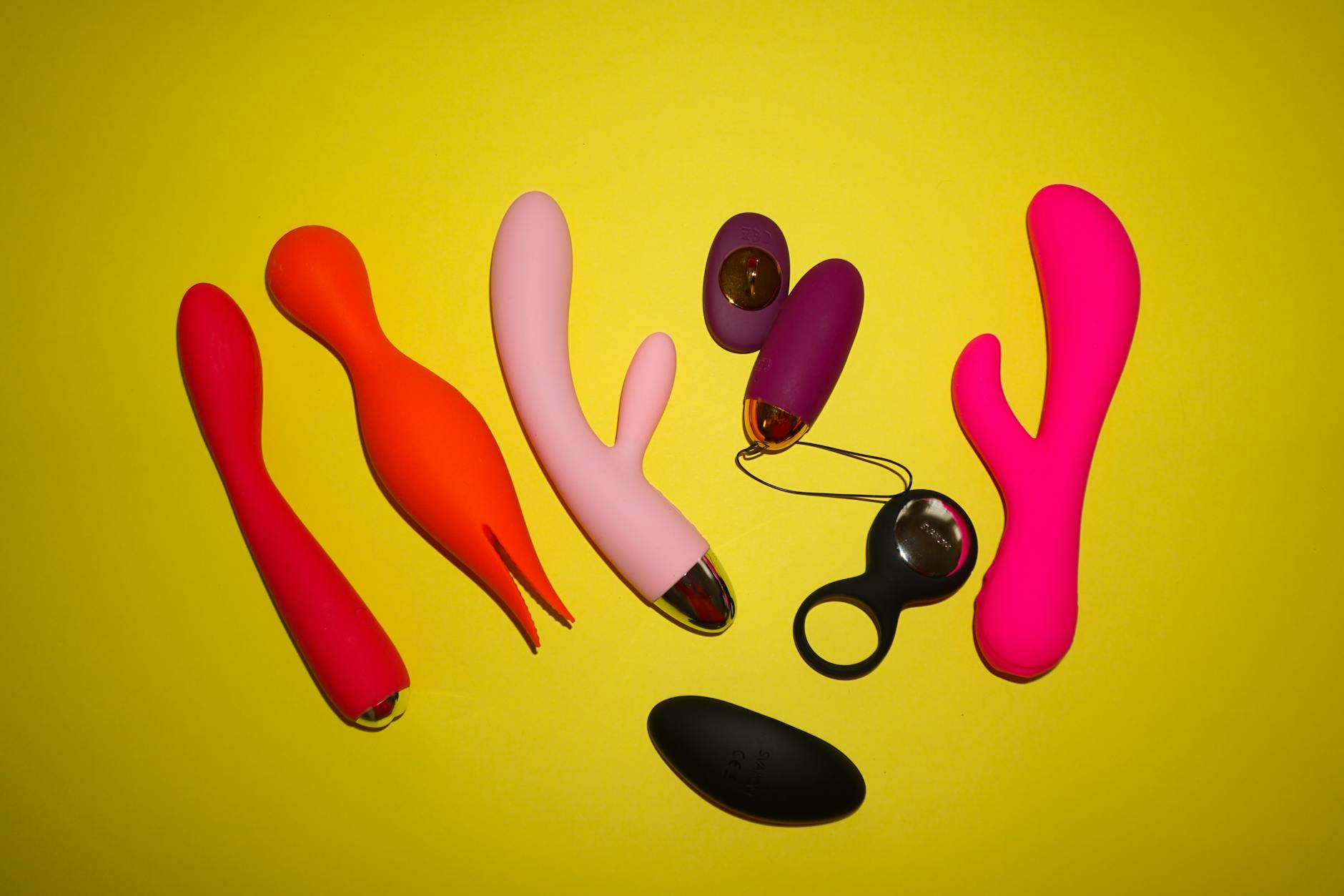 Hand holding a fresh lemon against a bright yellow background, symbolizing the citrus-inspired design of the Hello Nancy Lem vibrator